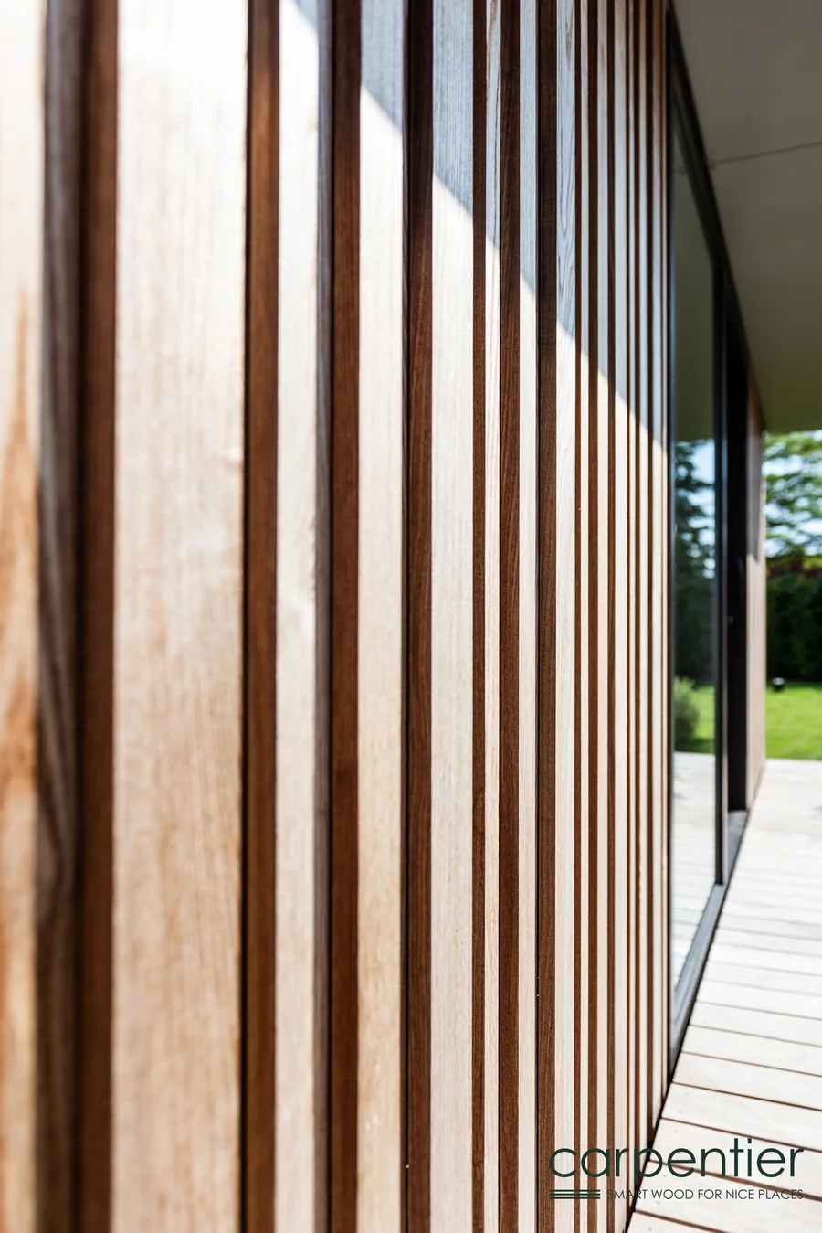Detailaufnahme einer Holzfassade im Relief-Profil mit Wechsel aus hellen und dunklen Latten