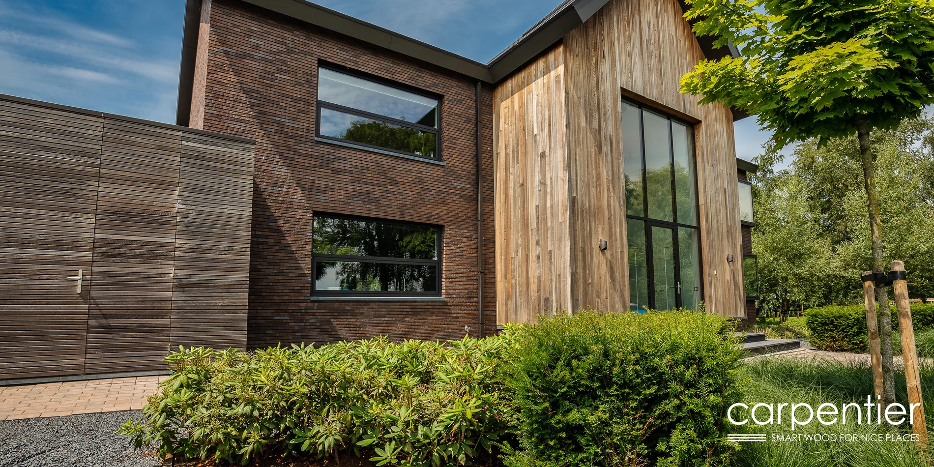 Private Villa mit Holzfassade kombiniert mit Klinker und raumhoher Verglasung